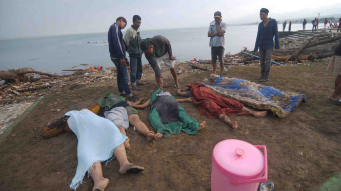 Sejumlah warga memeriksa jenazah yang ditemukan di sekitar pesisir pantai jalan Raja Moili Palu Timur, Palu