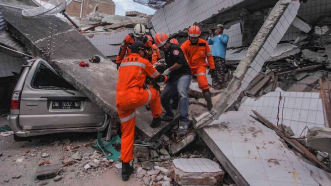 Petugas Basarnas membawa korban selamat gempa dan tsunami di Palu