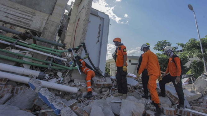Petugas Basarnas melakukan pencarian korban gempa dan tsunami di Hotel Roa Roa, Palu, Sulawesi Tengah, Minggu (30/9). Pencarian saat itu dilakukan tanpa bantuan alat berat. - Antara/MUHAMMAD ADIMAJA