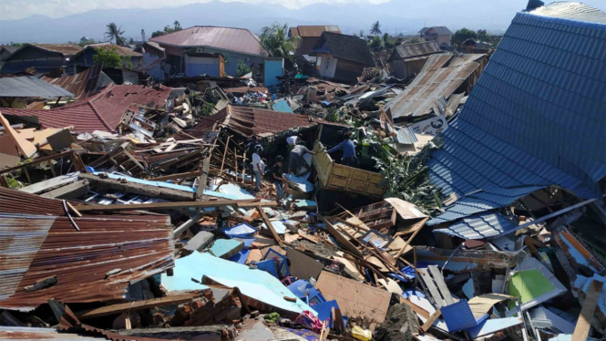 Warga mencari barang berharga di rumahnya yang hancur akibat gempa di Perumnas Bala Roa, Palu