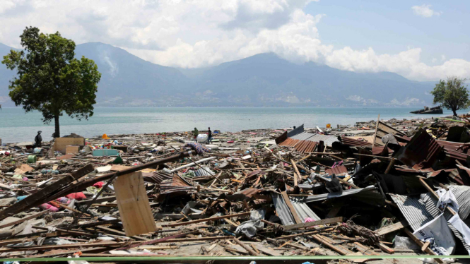 Warga mencari benda yang masih dapat digunakan di antara puing dan sampah yang terbawa gelombang tsunami pascagempa berkekuatan 7,4 SR di Palu Utara, Palu, Sulawesi Tengah