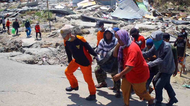 Tim Basarnas dibantu warga mengangkat jenazah saat evakuasi pascagempa di Kompleks Perumahan  Nasional Kelurahan Balaroa, Kota Palu, Sulawesi Tengah