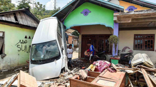 Satu unit mobil tersangkut di rumah warga akibat gempa dan tsunami, di Desa Loli Saluran, Kecamatan Banawa, Donggala, Sulawesi Tengah, Rabu, 3 Oktober 2018.