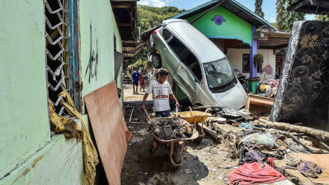 Penyintas membersihkan areal rumah mereka yang rusak pascagempa dan tsunami, di Desa Loli Saluran, Kecamatan Banawa, Donggala, Sulawesi Tengah, Rabu, 3 Oktober 2018.