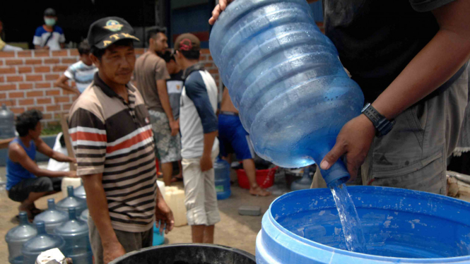 Warga korban gempa bumi Palu mengambil air di salah satu rumah warga di Pertigaan Petobo Palu, Sulawesi Tengah