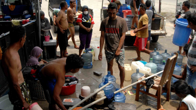 Warga korban gempa bumi Palu mandi dan mengambil air di salah satu rumah warga di Pertigaan Petobo Palu, Sulawesi Tengah