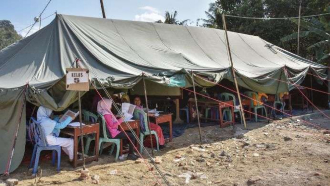 Sejumlah siswa korban gempa bumi belajar di tenda sekolah darurat.