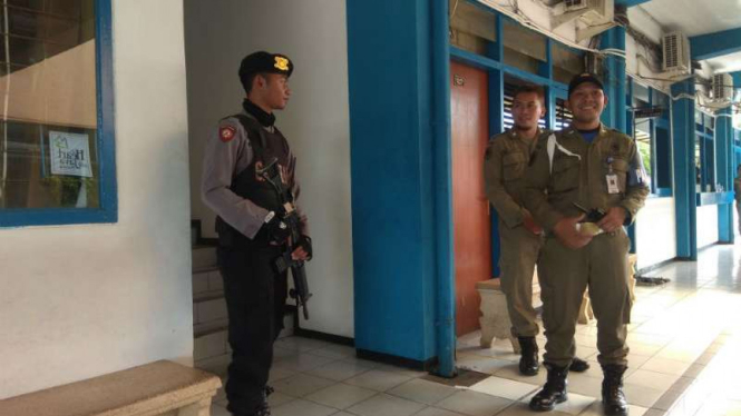 Personel Polisi bersenjata laras panjang bersama Satpol berjaga di teras kantor BPKAD Kabupaten Malang, Jawa Timur, saat KPK menggeledah kantor itu Selasa, 9 Oktober 2018.