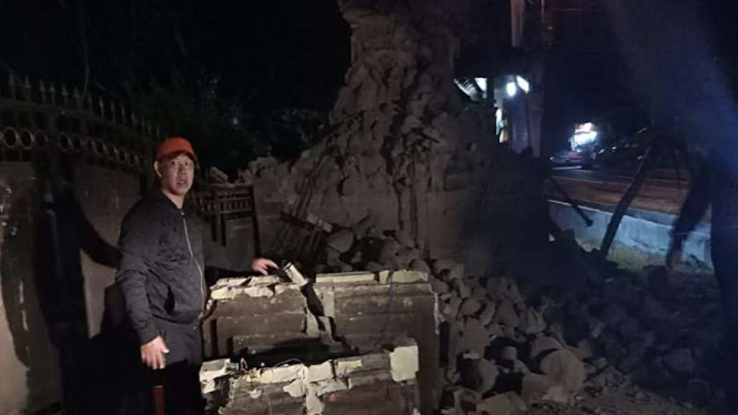 Warga menunjukkan bangunan yang rusak akibat gempa di Jawa Timur, Kamis (11/10).