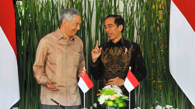 Presiden Indonesia Joko Widodo (kanan) berbincang dengan Perdana Menteri Singapura Lee Hsien Loong (kiri) sebelum penandatanganan kerjasama bilateral antara menteri-menteri Indonesia dan Singapura, di sela Pertemuan Tahunan IMF - World Bank Group 2018 di 