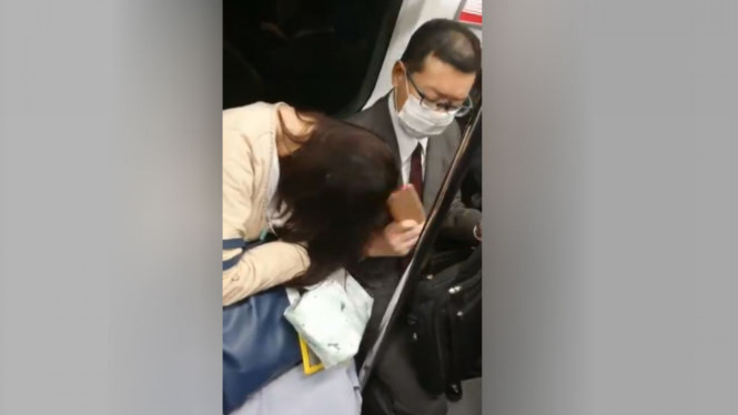 Wanita tertidur di kereta.