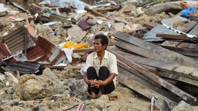 Abdullah (64), salah satu korban selamat dari bencana alam gempa dan pencairan tanah (likuifaksi) duduk disekitar puing rumahnya yang hancur dan tertimbun lumpur di Kelurahan Petobo, Palu, Sulawesi Tengah