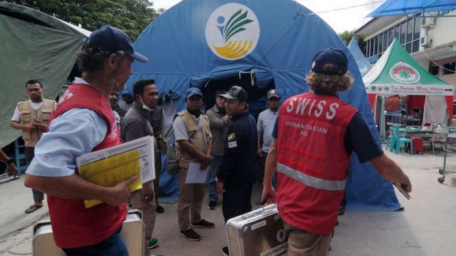 Dua relawan asing saat membantu korban gempa bumi di Palu, Sulawesi Tengah.