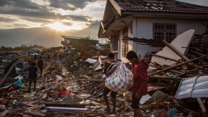 Para penyintas di Kelurahan Petobo mengais-ngais puing untuk mencari kerabat dan harta benda mereka. - Getty Images