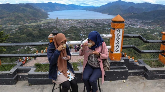 Pengunjung menyeruput kopi di atas puncak bukit Pantan Terong, Takengon, Aceh
