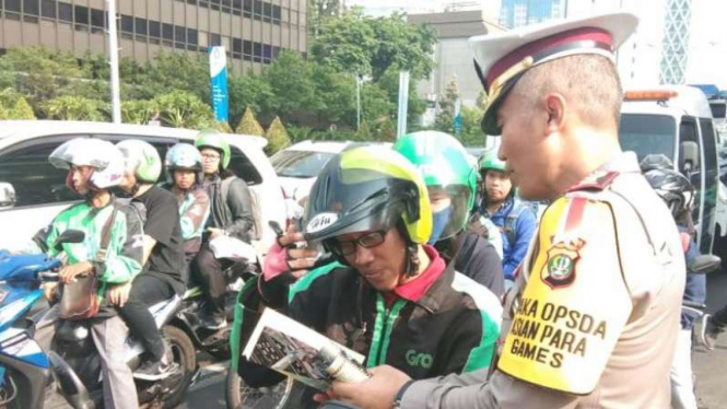 Direktorat Lalu Lintas Polda Metro bagikan brosur tilang elektronik.