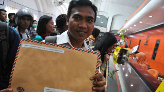Seorang pelamar calon pegawai negeri sipil (CPNS) memperlihatkan berkas pendaftaran lamarannya untuk dikirim di Kantor Pos Besar Medan, Sumatera Utara