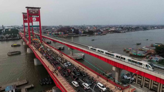 Rangkaian Light Rail Transit (LRT) Palembang melintas di atas Sungai Musi, Palembang, Sumatra Selatan