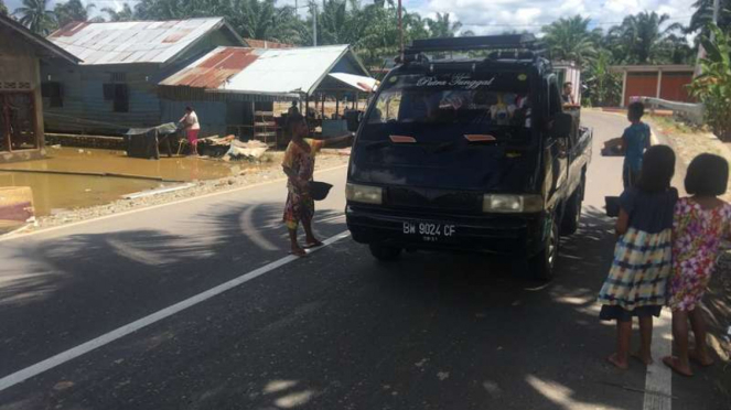 Anak-anak korban banjir di Pasaman Barat terpaksa turun ke jalan.