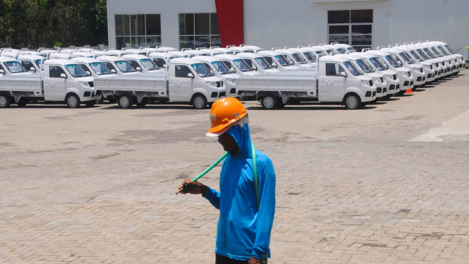 Pekerja berjalan di depan deretan mobil Esemka di pabriknya di Sambi, Boyolali, 