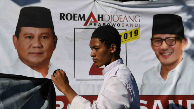 Seorang partisipan membentangkan baliho pasangan calon Presiden dan Wakil Presiden nomor urut 02 Prabowo Subianto dan Sandiaga Uno saat peresmian rumah pemenangan di Surabaya, Jawa TImur