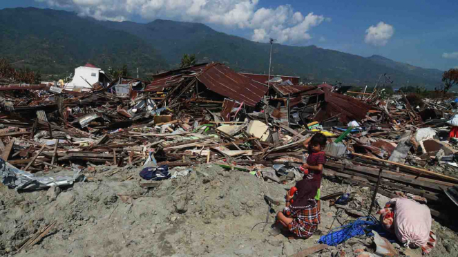 Seorang ibu bersama anaknya menyaksikan sisa-sisa reruntuhan rumahnya yang akan diratakan dengan tanah di area bekas likuifaksi di Kelurahan Balaroa, Palu, Sulawesi Tengah
