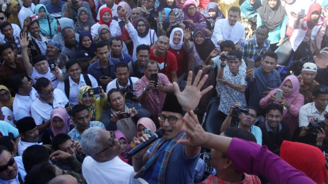 Calon Wakil Presiden Republik Indonesia no urut 02, Sandiaga Uno mengangkat tangannya (dua kiri ke kanan) saat berkunjung ke Pasar Raya Inpres II, Padang, Sumatera Barat, Jumat (19/18/2018). - ANTARA/Muhammad Arif Pribadi