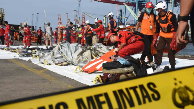 Petugas gabungan Basarnas, PMI, dan Polri mengevakuasi puing pesawat Lion Air JT 610 pascakecelakaan, di Pelabuhan Tanjung Priok, Jakarta