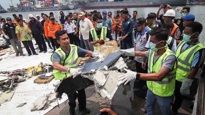 Petugas memindahkan puing-puing pesawat ke dalam mobil saat serah terima barang temuan kecelakaan Lion Air JT 620 di Pelabuhan Tanjung Priok, Jakarta