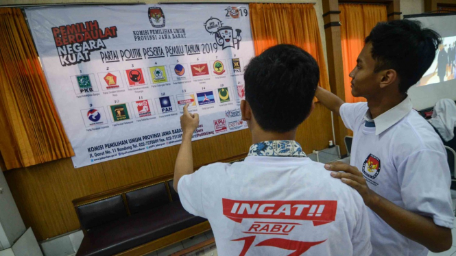 Dua siswa Sekolah Menangah Atas memperhatikan gambar partai politik peserta pemilu 2019 di Komisi Pemilihan Umum (KPU) Jawa Barat, Bandung