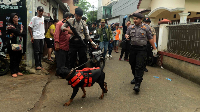 Polisi melakukan penyisiran dengan anjing pelacak di sekitar lokasi peristiwa pembunuhan satu keluarga, di kawasan Jatirahayu, Bekasi, Jawa Barat.