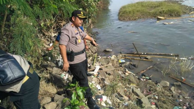 Polisi memperlihatkan lokasi penemuan mayat bayi kepala tak utuh di bantaran Sungai Cisadane Pintu 10, Koang Jaya, Karawaci, Tangerang, Banten, pada Kamis, 15 November 2018.