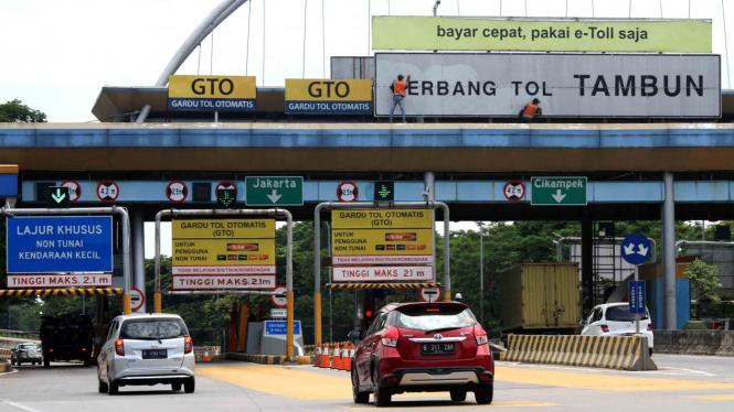Sejumlah pekerja membersihkan papan nama di pintu masuk Gerbang Tol Tambun, di Kabupaten Bekasi, Jawa Barat