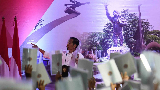 Presiden Joko Widodo meminta masyarakat menunjukkkan sertifikat saat Penyerahan Sertifikat Tanah Untuk Rakyat di Lapangan Ahmad Yani, Jakarta