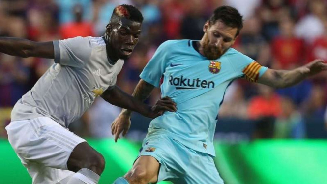 Gelandang Manchester United, Paul Pogba, berebut bola dengan Lionel Messi