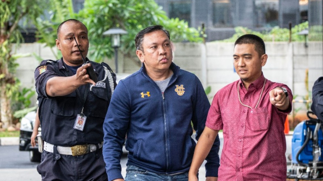 Bupati Pakpak Bharat Remigo Yolando Berutu (tengah) dikawal petugas KPK saat diamankan ke gedung KPK, Jakarta, Minggu (18/11/2018). 