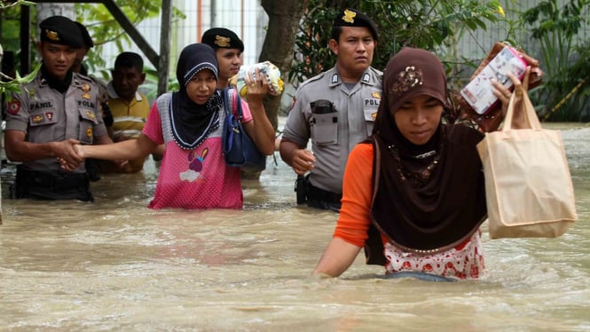 Personel Polisi Unit Reaksi Cepat (URC) Polres Lhokseumawe membantu mengevakuasi warga yang terkepung banjir, di Kecamatan Samudera Geudong, Aceh Utara, Aceh