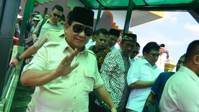 Calon presiden nomor urut 02 Prabowo Subianto menyapa pendukungnya usai menziarahi Makam Abah Anom Suryala, di Kabupaten Tasikmalaya, Jawa Barat