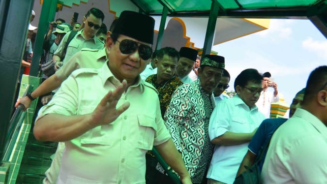 Calon presiden nomor urut 02 Prabowo Subianto menyapa pendukungnya usai menziarahi Makam Abah Anom Suryala, di Kabupaten Tasikmalaya, Jawa Barat