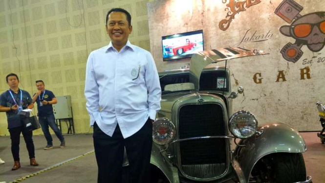 Ketua DPR, Bambang Soesatyo berfoto di depan mobil klasik.
