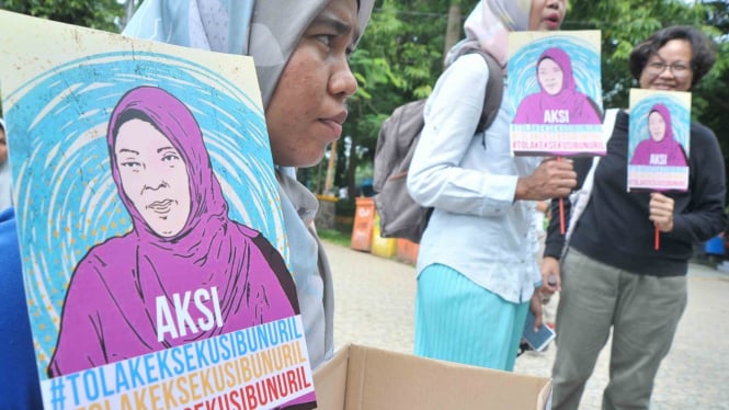 Peserta aksi menunjukkan poster dan kotak donasi pada aksi Tolak Eksekusi Baiq Nuril Maknun di Taman Kamabang Iwak Palembang