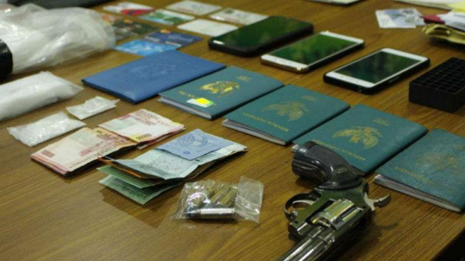 Uang, paspor dan senapan disita Polda Riau dari bandar narkoba.