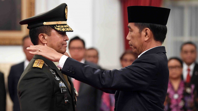 Presiden Joko Widodo (kanan) memasangkan tanda pangkat jabatan kepundak  Kepala Staf Angkatan Darat (KSAD) yang baru Jenderal TNI Andika Perkasa (kiri) seusai pelantikan di Istana Merdeka, Jakarta, Kamis, 22 November 2018.