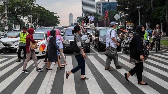 Warga menyebrang menggunakan fasilitas Pedestrian Light Controlled Crossing (Pelican Crossing) di Halte GBK, Jalan Jenderal Sudirman, Senayan, Jakarta, Kamis, 22 November 2018.