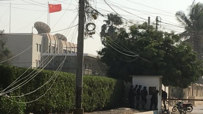 Pasukan paramiliter dan polisi berlindung di balik tembok dekat gedung konsulat Cina di Karachi, Pakistan.-Reuters