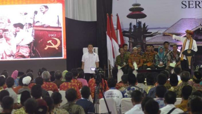 Presiden Jokowi menunjuk ke layar foto mirip dirinya saat Aidit berpidato.