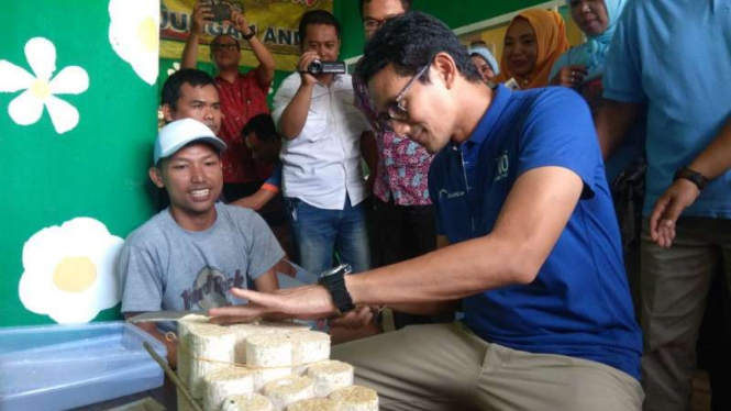 Calon wakil presiden Sandiaga Salahudin Uno belajar mengiris tempe setipis kartu ATM di sentra industri tempe Sanan, Kota Malang, Jawa Timur, pada Jumat, 23 November 2018.