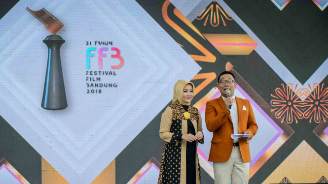 Gubernur Jawa Barat Ridwan Kamil (kanan) bersama Istri, Atalia Praratya (kiri) memberikan kata sambutan sekaligus membuka Festival Film Bandung yang diadakan di Gedung Sate, Bandung, Jawa Barat