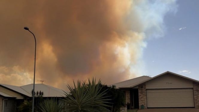 Asap pekat mengepul diatas kota Gracemere yang berasal dari kebakaran lahan yang dengan cepat merambat di kota di Queensland tengah itu.