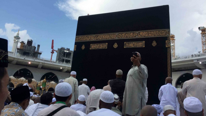 Sejumlah umat berswafoto dengan latar belakang Kabah di Masjidil Haram, Mekkah.